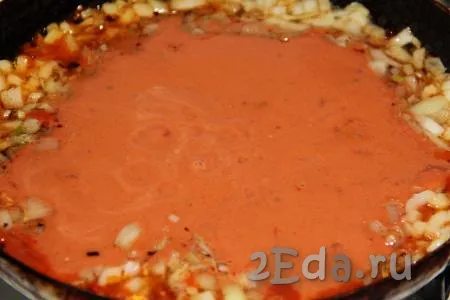 Влить получившийся томатно-сметанный соус в сковороду к луку и чесноку, перемешать и слегка прогреть.