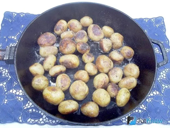 Молодой картофель жарится в сковороде на сливочном масле