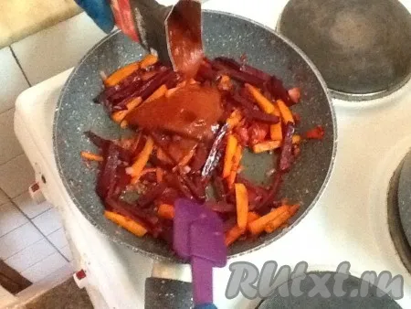 К овощам на сковородке добавить томатную пасту и перемешать, посолить и поперчить. Продолжать тушить овощи на медленном огне.