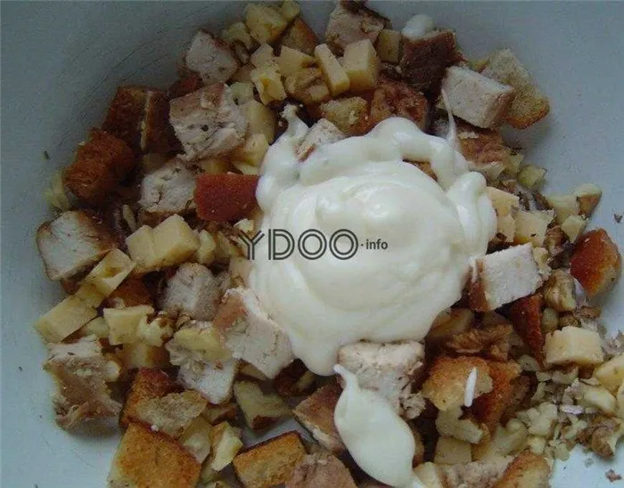 пшеничные сухарики, куриная грудка, сыр, нарезанные кубиками, измельченные грецкие орехи и майонез в глубокой миске