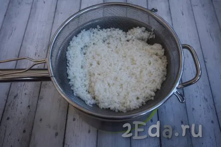 Отваренный до полуготовности рис откидываем на дуршлаг (или мелкое сито), промываем под проточной холодной водой, даём стечь воде.