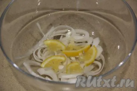 Лук нарезать полукольцами. Лимон нарезать на кружочки, которые потом разрезать на 4 части. На дно миски выложить половину нарезанных лука и лимона.