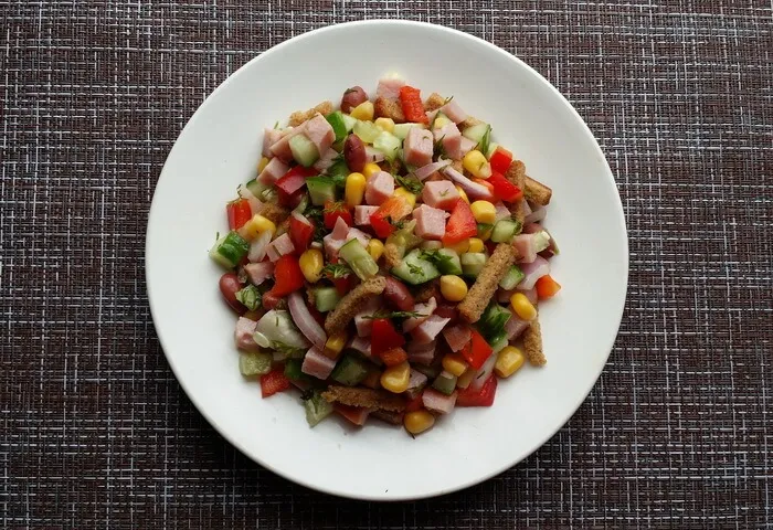 Салат с ветчиной, кукурузой, фасолью, сухариками, перцем и огурцом