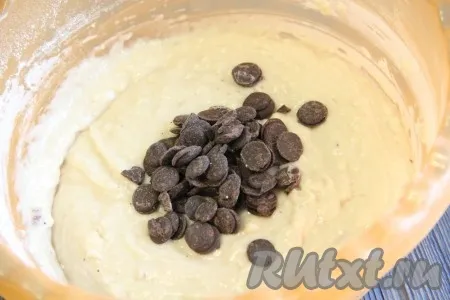Далее в тесто для кекса всыпать шоколадные капли и аккуратно подмешать их в тесто. 