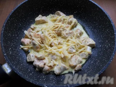 Газ выключить и посыпать куриное филе в сметанном соусе тертым сыром. Накрыть сковороду крышкой. Оставить до расплавления сыра.