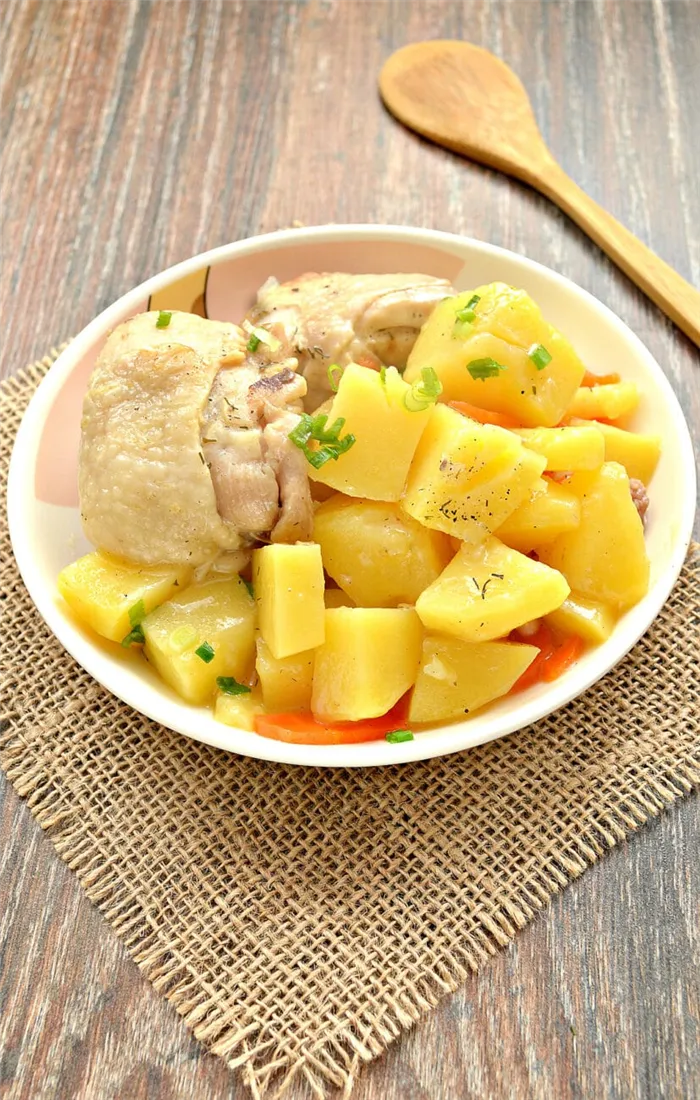 Куриные бедра, тушенные с картофелем и овощами на сковороде