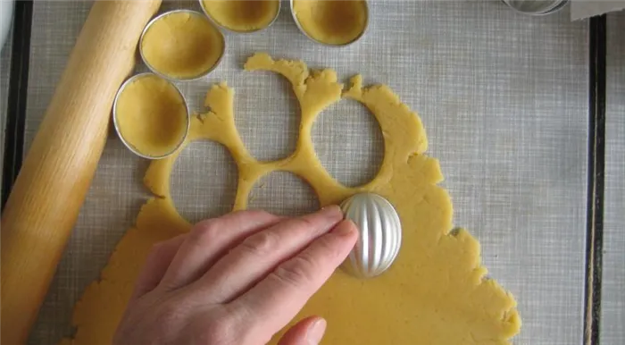 Раскатать тесто, вырезать и выложить в формочки для печенья