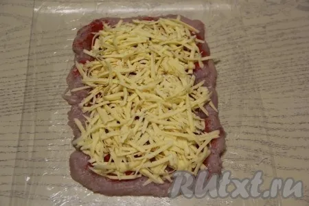Сыр натереть на тёрке и выложить ровным слоем на куриное филе.