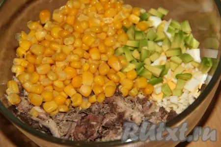 Слить из банки с консервированной кукурузой жидкость, а затем выложить кукурузку в салатник. 