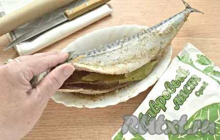 В брюшко рыбы помещаем пару лавровых листочков.