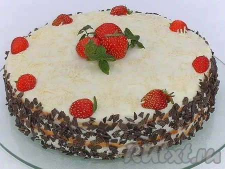 Верхний корж и бока торта смазываем кремом. Наивкуснейший торт с кремом из творожного сыра и сгущёнки украшаем тёртым шоколадом, клубникой и мятой. 