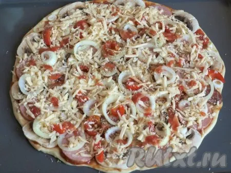 Посыпать пиццу натёртым твёрдым сыром. 