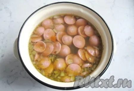 Когда овощи в супе с чечевицей будут готовы, добавить в кастрюлю нарезанные сосиски и варить еще 5-7 минут. Суп посолить и поперчить по вкусу. 