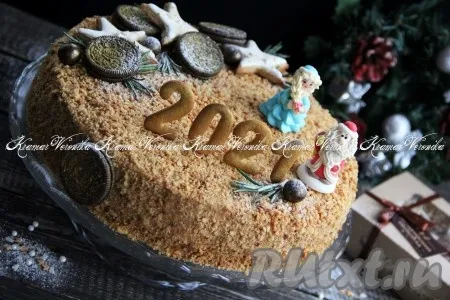 Обсыпать верх и бока арахисового торта крошкой и украсить по желанию (у меня торт украшен в новогодней тематике: фигурки из сахара, имбирное печенье и 