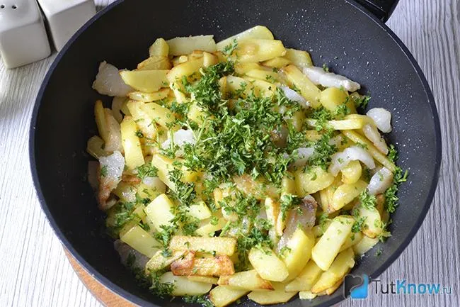 Добавление зелени к картошке с салом на сковороде
