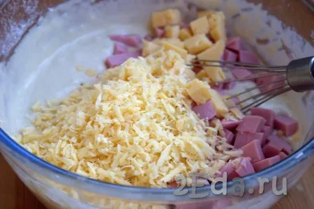 Затем в тесто добавить кубики колбасы и сыра, всыпать натёртый сыр, вмешать их в тесто.