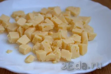 Половину сыра нарезать на кубики небольшого размера.
