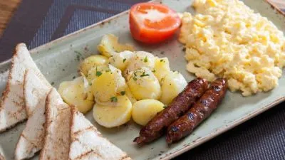 Американский завтрак из сосисок, картофеля и омлета