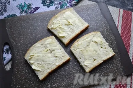 Ломти батона отрезать так, чтобы получились квадраты (или взять тостовый белый хлеб). Смазать ломти сливочным маслом. 