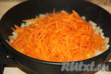 Обжарить лук, не забывая помешивать, на среднем огне в течение 5 минут, затем выложить очищенную и натёртую на крупной тёрке морковку. 