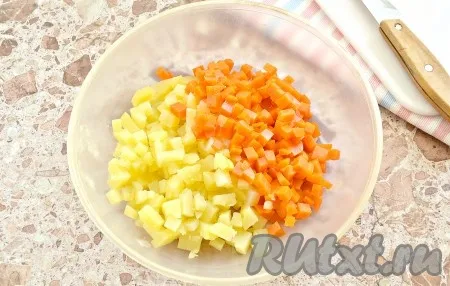 Заранее для салата отвариваем в кожуре картофель и морковь (на варку обычно требуется 20-25 минут, полностью готовые овощи должны легко прокалываться вилкой), корнеплоды остужаем и затем очищаем. Отвариваем куриные яйца вкрутую (варим 8-10 минут с начала закипания воды), остужаем их и очищаем. Ветчину выбирайте на свой вкус. Вместо укропа можно взять зелёный лук. Морковь и картофель нарезаем на мелкие кубики, выкладываем в достаточно объёмную миску. Нарезая ингредиенты для салата 