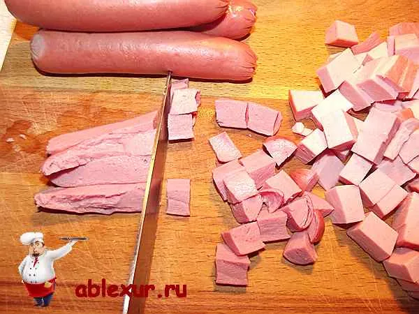 нарезаю сосиски и колбасу в салат из фасоли с огурцами 