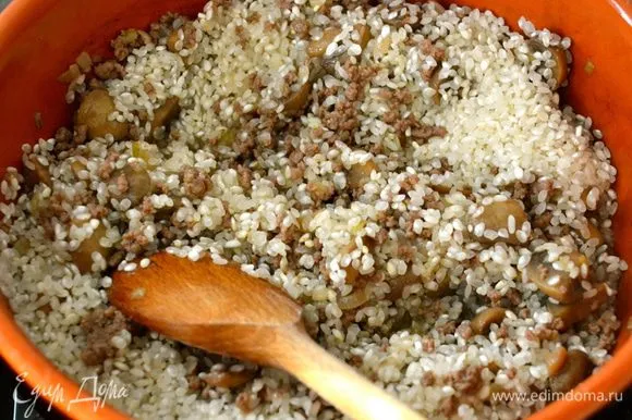 Выложить рис и как следует перемешать с мясом, грибами и луком. Позволить рису напитаться всеми 
