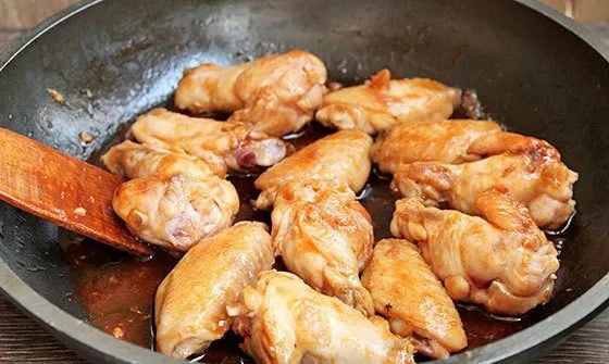 Обжаренные куриные крылья в сковороде с соусом