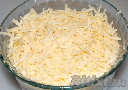 Сыр натереть на крупной терке и выложить в салатницу.