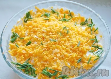 Сыр смазать майонезом и поверх него выложить натертый на мелкой терке желток.