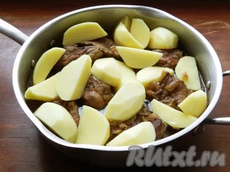 Добавить к говядине очищенный и нарезанный крупными ломтиками картофель, накрыть крышкой и готовить жаркое еще 30 минут, до мягкости картошки. 