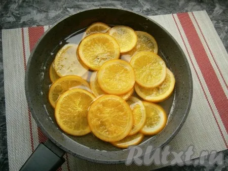 Далее на слабом огне варить апельсины в сиропе минут 40-50, периодически их перемешивая. Кожица апельсинов должна изменить цвет и стать полупрозрачной. 