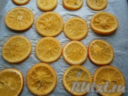Духовку разогреть до 160 градусов и отправить в неё апельсины минут на 15. За это время они подсушатся и окончательно карамелизируются. По прошествии времени достать апельсины из духовки и дать немного остыть. 