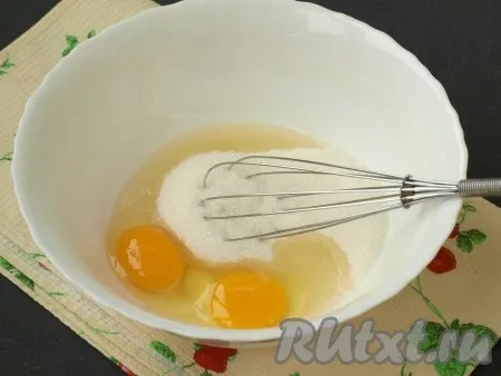 Разбить в миску яйца, добавить сахар и тщательно взбить венчиком до пышной массы.