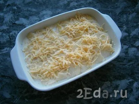 Залить картофель получившейся сливочной смесью, сверху посыпать оставшимся натертым сыром.