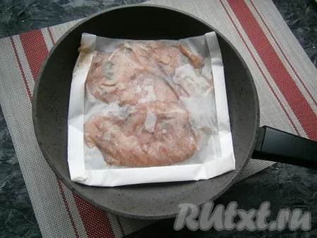 Разогреть сковороду и выложить конверт из пергамента с куриным филе. Жарить мясо нужно на огне чуть ниже среднего в течение 4 минут с одной стороны. 