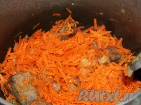 Затем кладём натертую на терке морковь. 