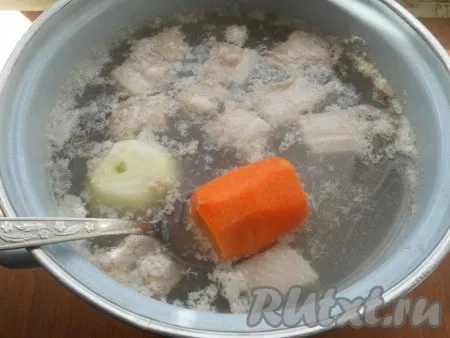 Залить водой, добавить одну целую очищенную луковицу и половину очищенной моркови. Поставить кастрюлю на огонь, довести до кипения, убрать пену. Бульон посолить, варить мясо на слабом огне минут 40. 