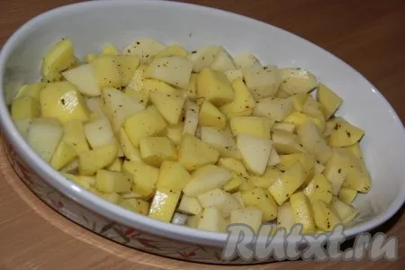 Картофель почистить, нарезать средними кубиками, посолить, добавить специи (я использовала специи для картофеля). Выложить картошку на дно жаропрочной формы. 