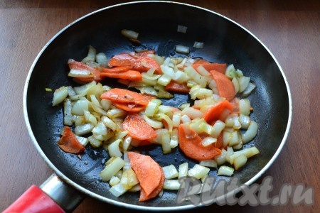 В ту же сковороду влить еще немного растительного масла и выложить нарезанный кубиками репчатый лук и нарезанную тонкими полу кружками морковь, обжарить овощи, иногда помешивая, до мягкости. 