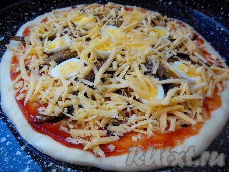 Посыпьте пиццу со шпротами сыром и запекайте в разогретой духовке при температуре 180 градусов в течение 10-15 минут. 