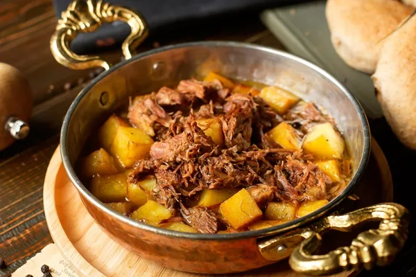 copper pan with potato and lam stew cooked in oil - Мясо с айвой