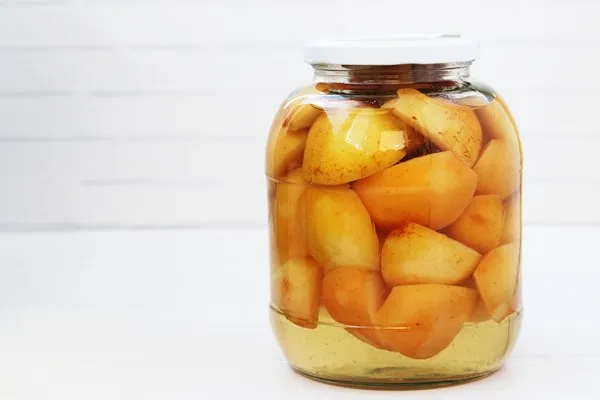 canned apples in syrup in a jar on a white background - Компот из айвы