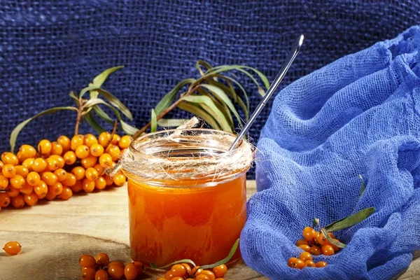 homemade jam glass jar with sea buckthorn jam blue canvas 2 - Желе из облепихи