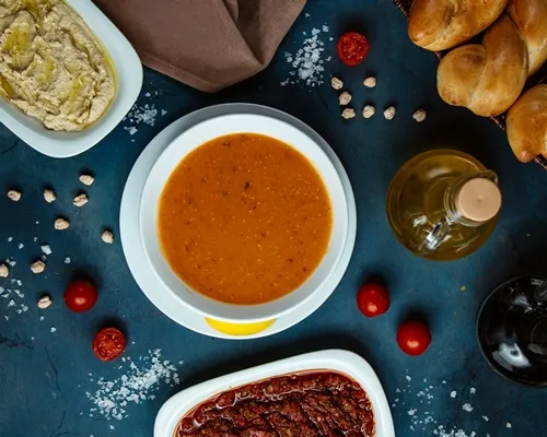 top view of lentil soup and side dishes and bread - Томатный суп с чечевицей